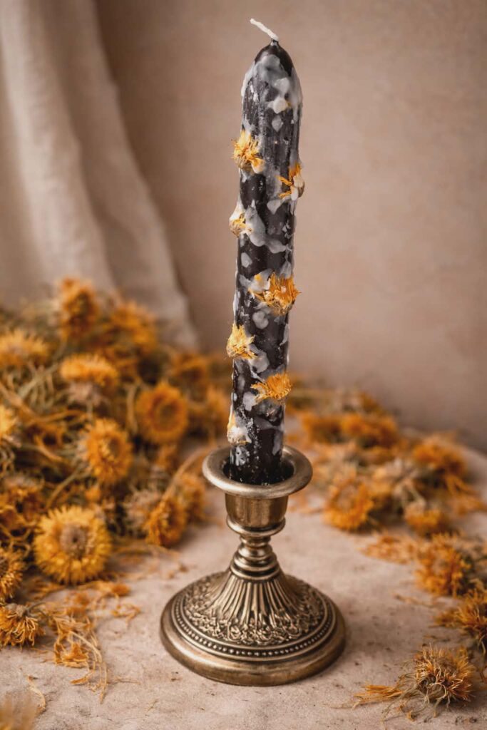 Black candle with calendula